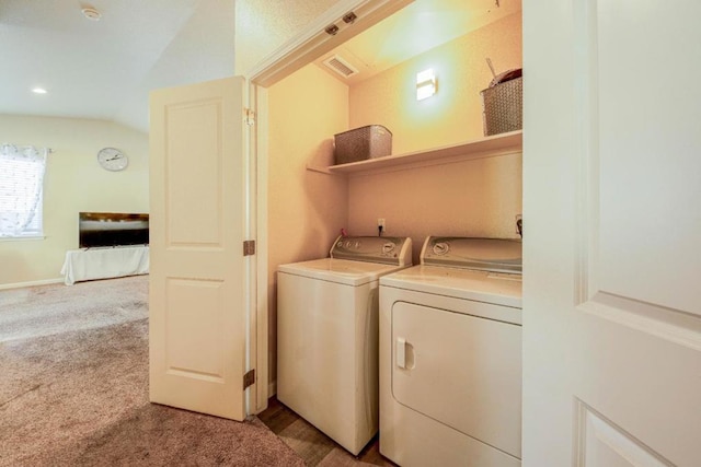 laundry area with washer and clothes dryer and light colored carpet