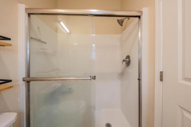 bathroom featuring an enclosed shower and toilet