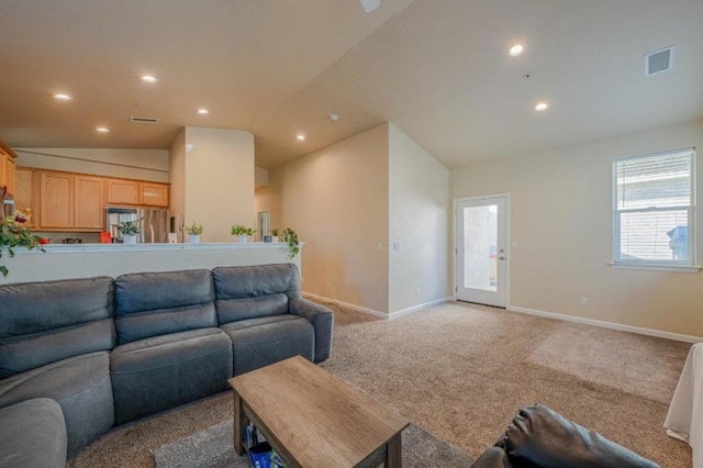 living room featuring vaulted ceiling and light colored carpet