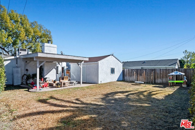 rear view of house with a yard and a patio