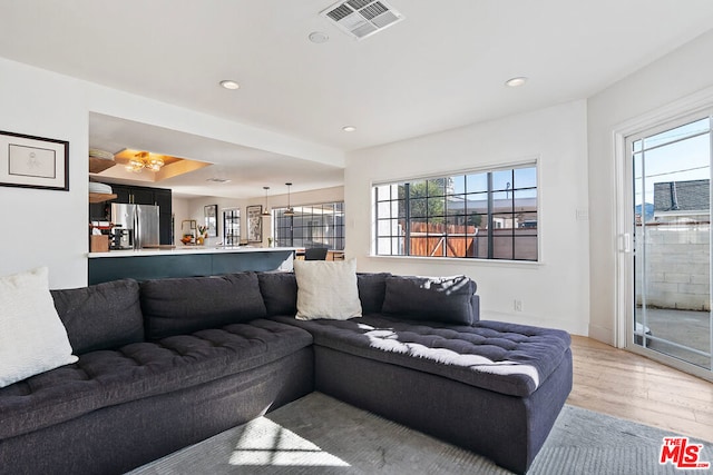 living room with plenty of natural light and light hardwood / wood-style flooring