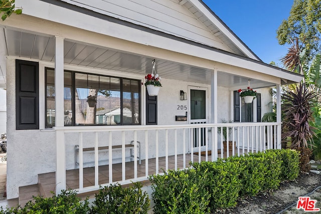 view of exterior entry featuring a porch