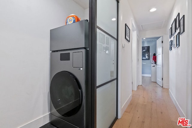 clothes washing area with light wood-type flooring and washer / dryer