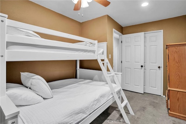 carpeted bedroom featuring ceiling fan and a closet