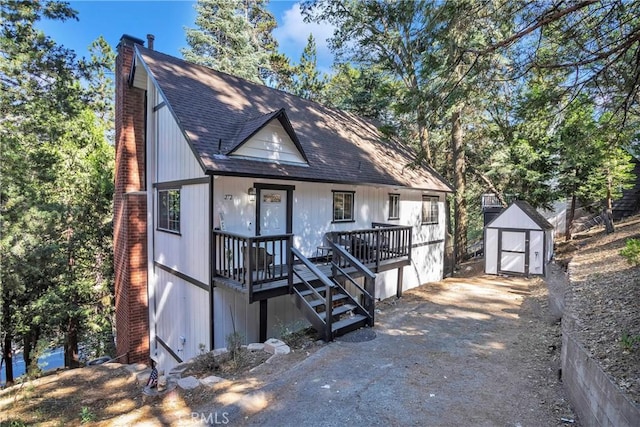 view of front facade with a wooden deck and a storage shed