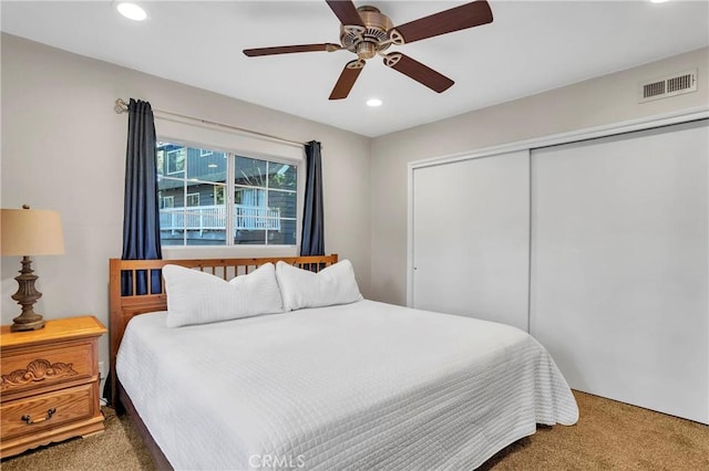 carpeted bedroom featuring ceiling fan and a closet