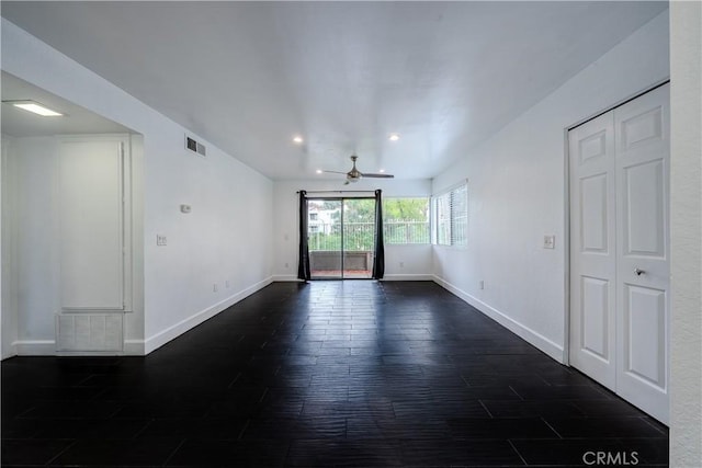 spare room featuring dark hardwood / wood-style flooring and ceiling fan