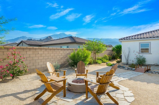 view of patio featuring an outdoor fire pit and a mountain view