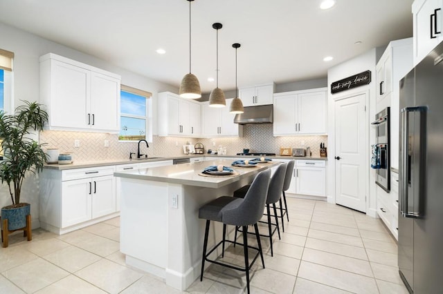 kitchen with white cabinetry, pendant lighting, a center island, and sink