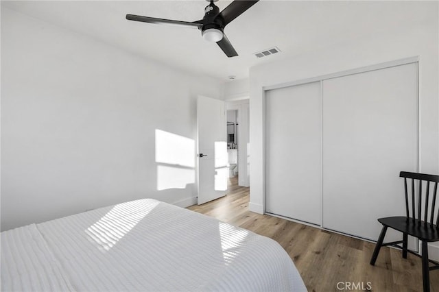 bedroom with ceiling fan, a closet, and light hardwood / wood-style flooring