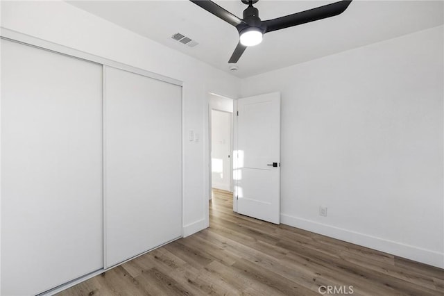 unfurnished bedroom with ceiling fan, a closet, and light hardwood / wood-style flooring