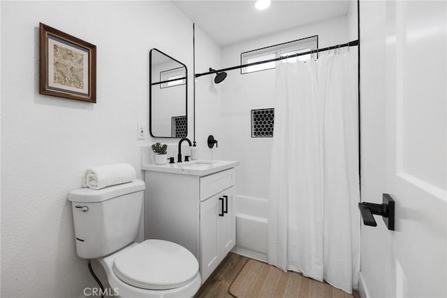 full bathroom with hardwood / wood-style floors, toilet, vanity, and shower / bath combination with curtain