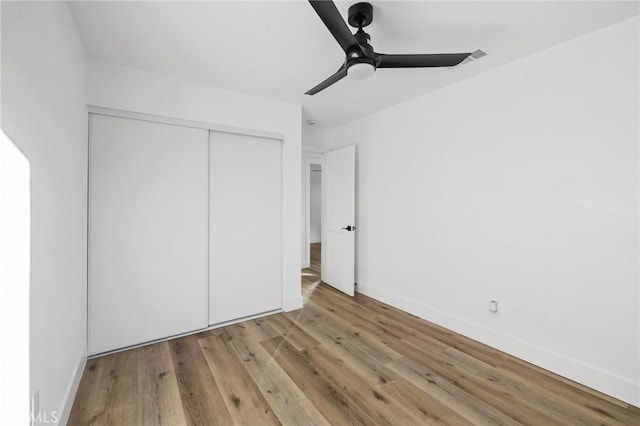 unfurnished bedroom with ceiling fan, a closet, and light hardwood / wood-style flooring