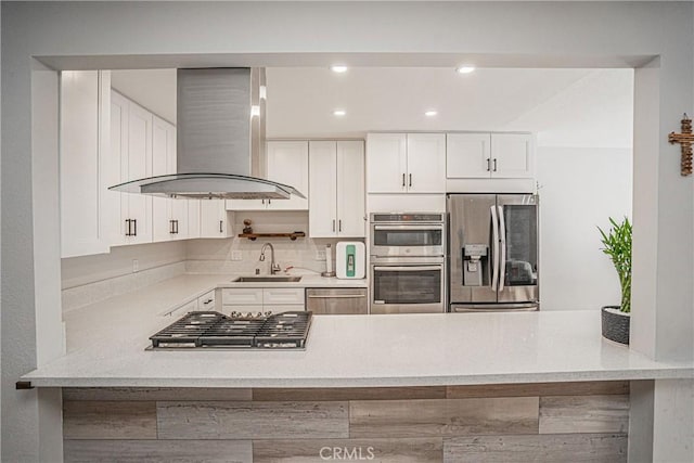 kitchen with light stone countertops, white cabinets, appliances with stainless steel finishes, island exhaust hood, and sink