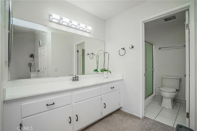 bathroom featuring toilet, tile patterned floors, a shower with door, and vanity