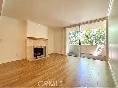 unfurnished living room featuring ornamental molding and hardwood / wood-style floors