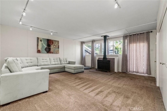 living room featuring carpet and a wood stove