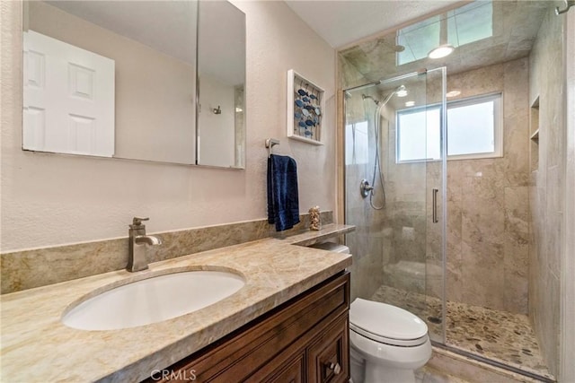 bathroom featuring vanity, an enclosed shower, and toilet