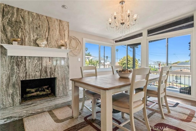 dining space with a fireplace, light hardwood / wood-style floors, and a notable chandelier