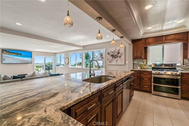 kitchen featuring sink, appliances with stainless steel finishes, pendant lighting, light stone countertops, and backsplash