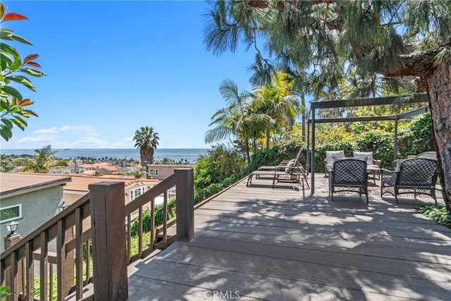 view of community with a deck with water view and a view of the beach