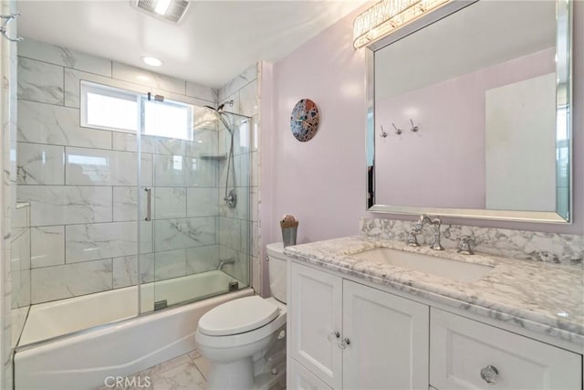 full bathroom featuring vanity, shower / bath combination with glass door, and toilet