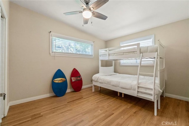 bedroom with ceiling fan, multiple windows, and light hardwood / wood-style flooring