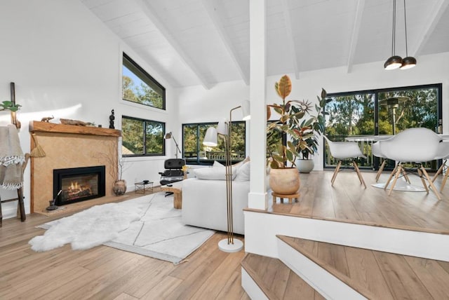 living room featuring beamed ceiling, high vaulted ceiling, and light hardwood / wood-style floors