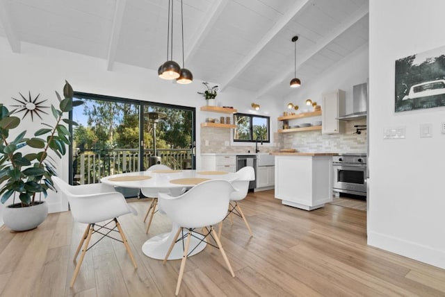 dining room featuring beamed ceiling, high vaulted ceiling, and light wood-type flooring