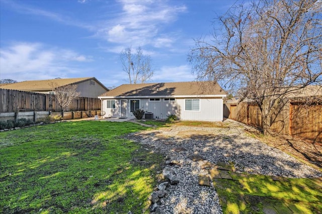 back of property with central air condition unit and a lawn