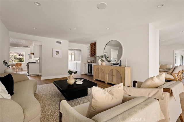 living room with baseboards, visible vents, dark wood-type flooring, and recessed lighting