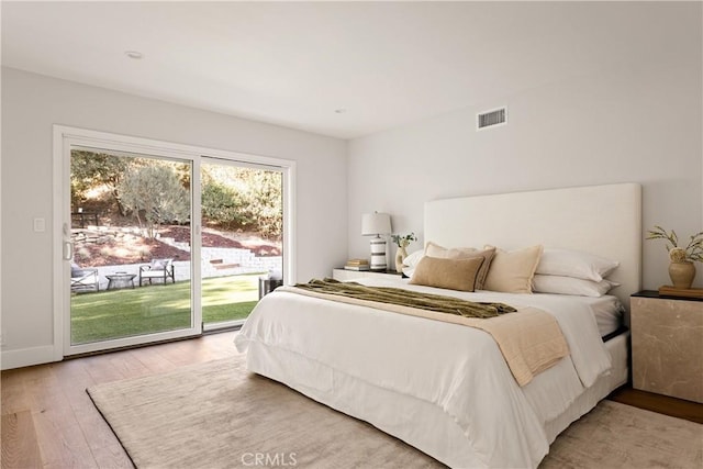 bedroom featuring access to exterior and light hardwood / wood-style flooring