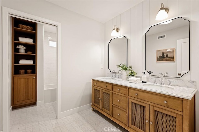 full bath with visible vents, a sink, baseboards, and double vanity