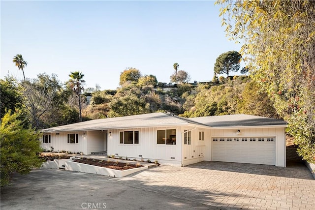 ranch-style house with crawl space, an attached garage, and decorative driveway