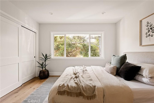 bedroom with light hardwood / wood-style flooring and a closet