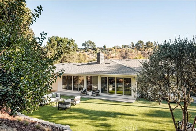 4031 Deerhorn Dr, Sherman Oaks, CA 91403 - rear view of house with a chimney, a lawn, an outdoor living space, and a patio