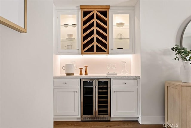 bar featuring white cabinetry, dark wood-type flooring, and beverage cooler