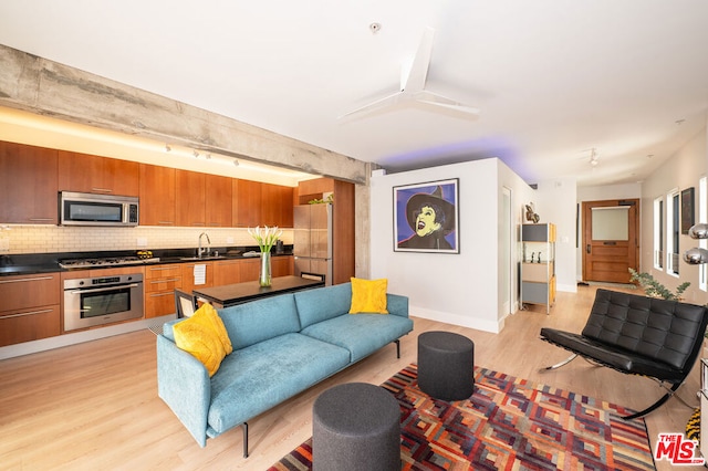 living room with light hardwood / wood-style floors and sink