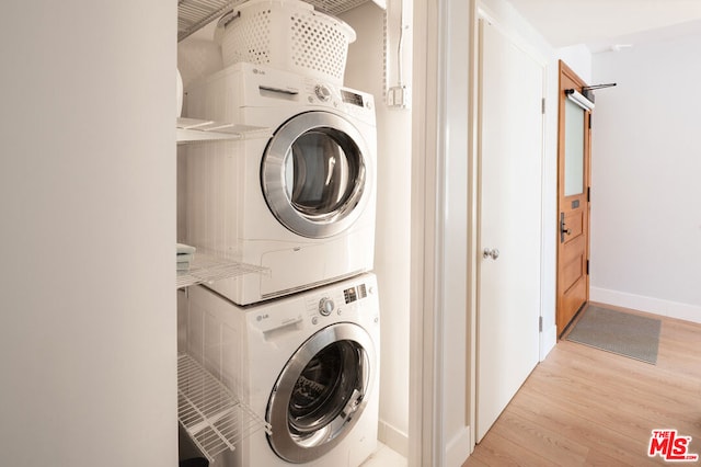 clothes washing area with stacked washer and clothes dryer and light hardwood / wood-style flooring