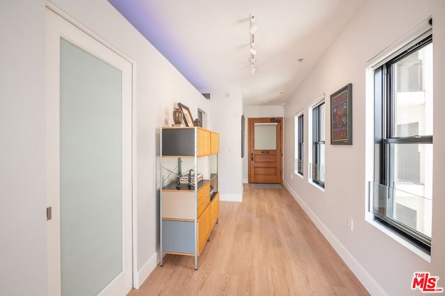 hallway with light wood-type flooring and rail lighting