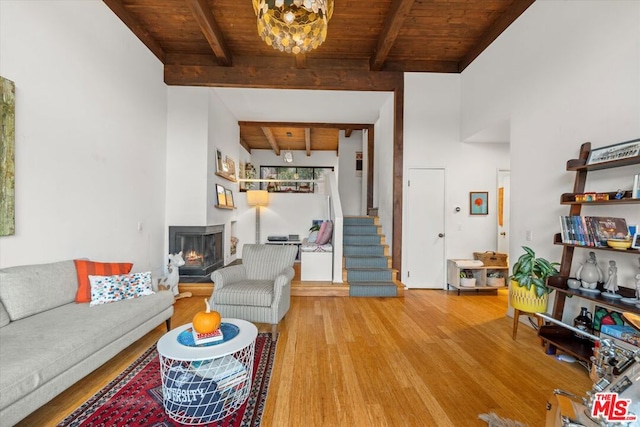 living room featuring an inviting chandelier, wood ceiling, hardwood / wood-style floors, a multi sided fireplace, and beamed ceiling