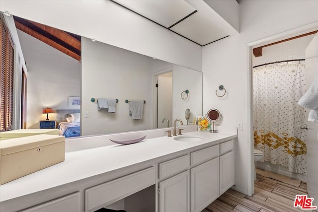 bathroom featuring toilet, vanity, walk in shower, and vaulted ceiling