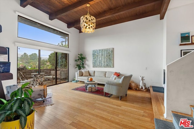 living room with light hardwood / wood-style floors, a high ceiling, beam ceiling, and wood ceiling