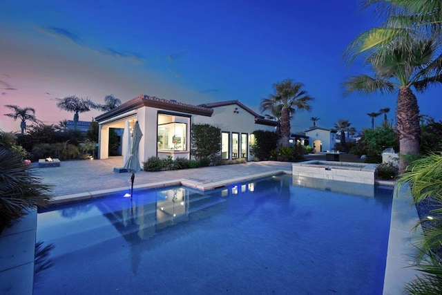 pool at dusk featuring a patio area