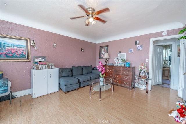 living room with ceiling fan and light hardwood / wood-style flooring