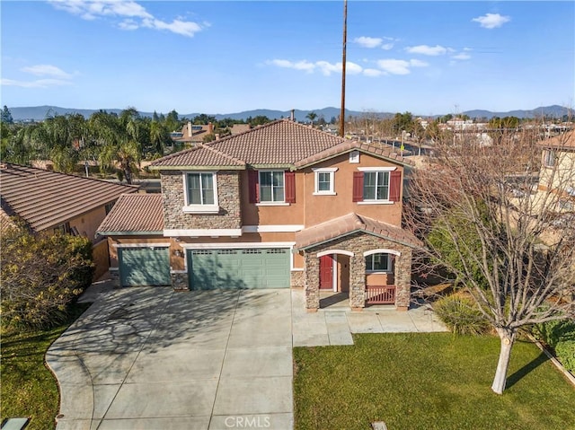 mediterranean / spanish house with a front yard, a mountain view, and a garage