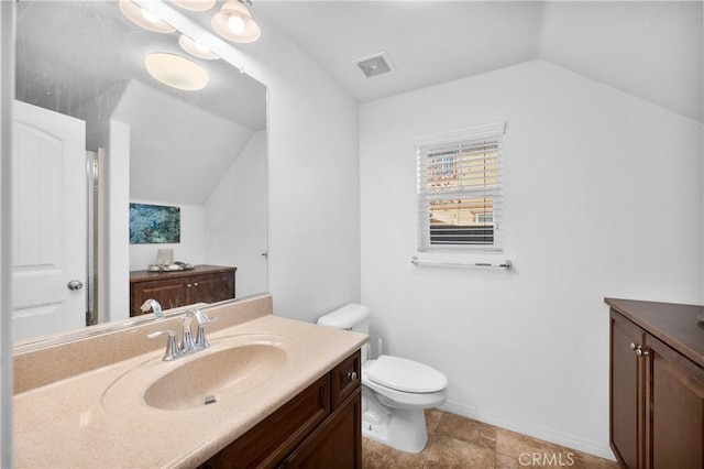 bathroom with toilet, vanity, and vaulted ceiling