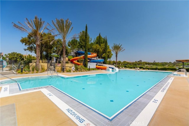 view of pool featuring a patio area and a water slide