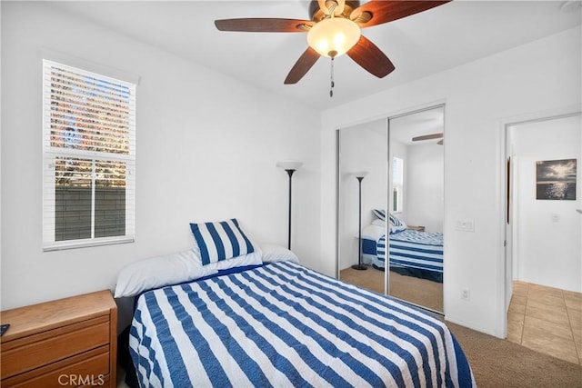 bedroom featuring ceiling fan, a closet, and light carpet