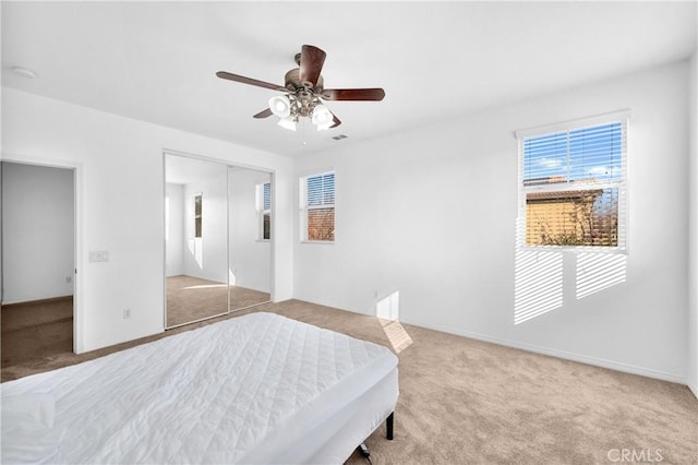 unfurnished bedroom featuring ceiling fan, light colored carpet, and a closet